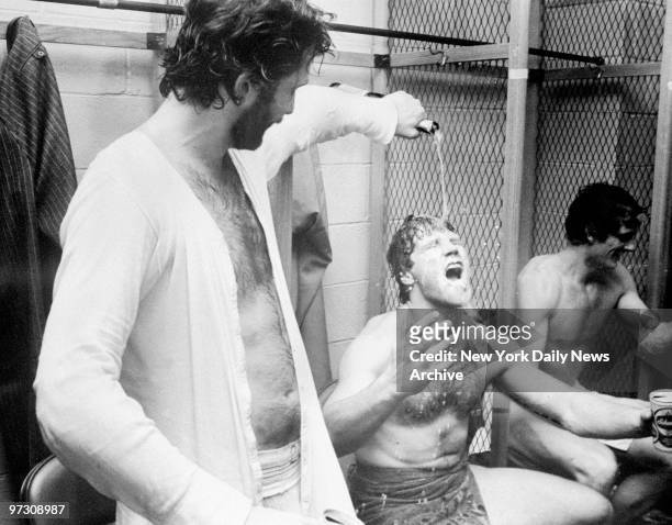 New York Islanders' Dave Lewis pours the champagne for Denis Potvin in the locker room celebration after their victory over the New York Rangers at...