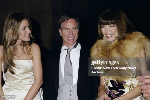 Tommy Hilfiger is flanked by Aerin Lauder and Vogue editor Anna Wintour at the Costume Institute Gala "Rock Style," an exhibit of rock 'n' roll...