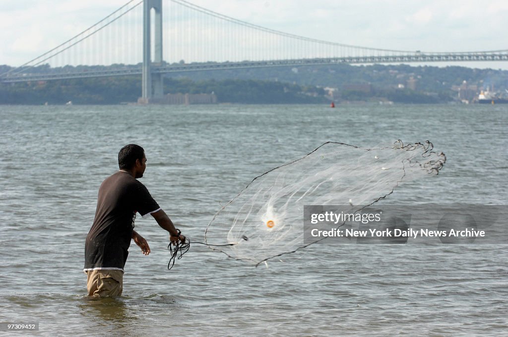 Danny Shivnandan catches mullets in hi fishing net at Coney