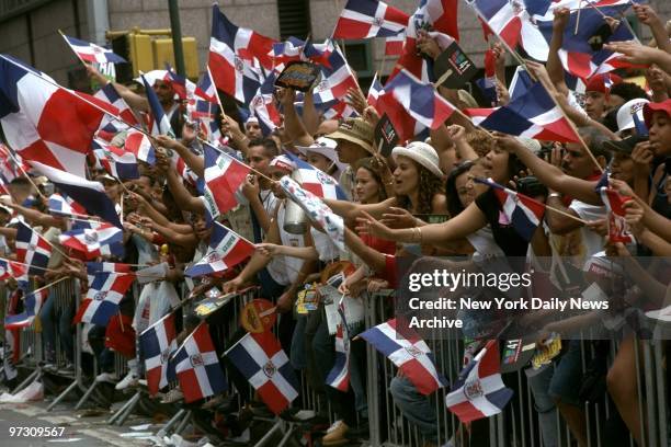 Spectators provide a sea of flags, with plenty of waves, to encourage marchers as the Dominican Day Parade makes its way up Sixth Ave., from 39th to...