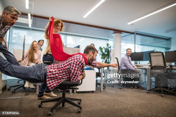 gruppe von verspielten kollegen spaß auf eine pause im casual büro. - superheld stock-fotos und bilder