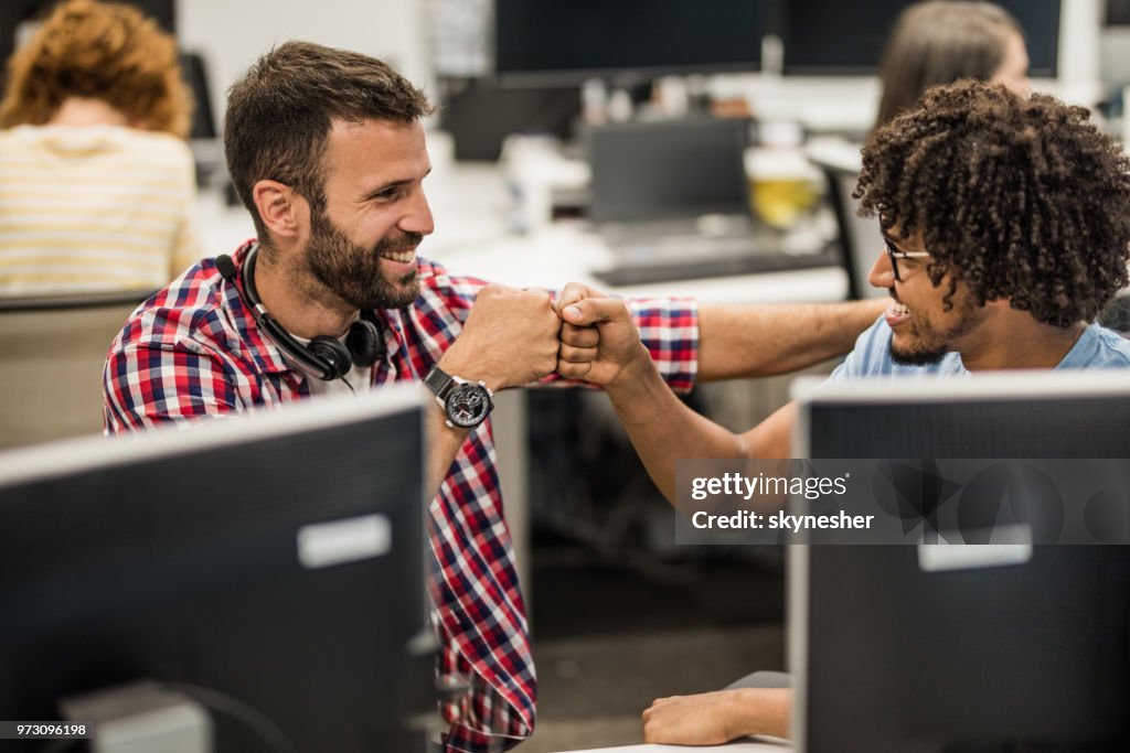 Happy Computer Programmers Giving Each Other Fist Bump In The Office ...
