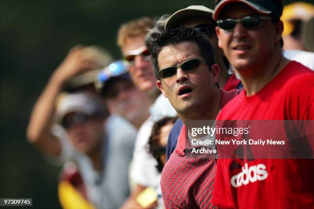 Spectators watch Tiger Woods' tee shot on the 14th hole during his third round of play at the 87th PGA Championship at Baltusrol Golf Club in...