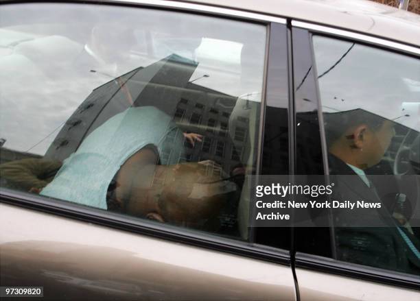 Darryl Littlejohn ducks his head in the back of a car as he is driven from Queens Supreme Court to the 112th Precinct stationhouse for a lineup...