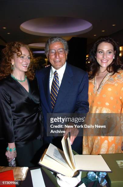 Tony Bennett leafs through a family photo album given to him by daughters Antonia and Joanna during an 80th birthday bash for the legendary singer at...