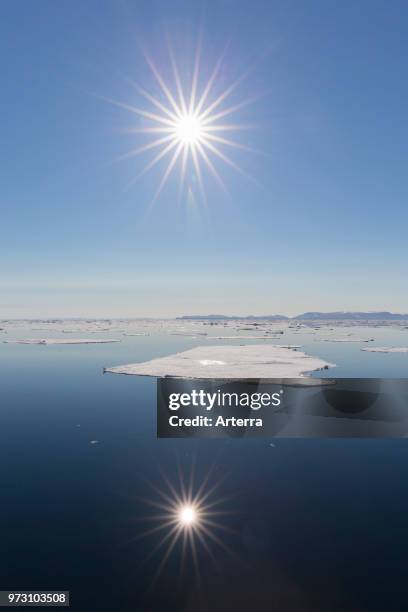 Midnight sun over the Arctic Ocean with drifting ice floes, north of the Arctic Circle at Nordaustlandet, Svalbard / Spitsbergen, Norway.