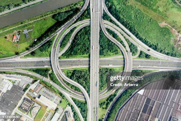 Aerial view over highway roundabout interchange / motorway interchange with slip roads leading to industrial estate.
