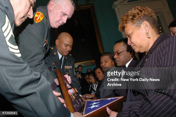 Medals and a flag are presented to Manuel Moreno and Francisca de la Cruz, parents of Pfc. Luis Moreno, who gave his life fighting in Iraq. Moreno, a...
