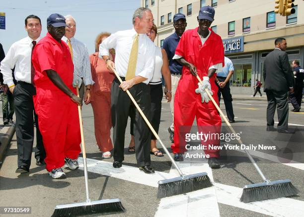 Mayor Michael Bloomberg helps to push a broom in the Bronx after he and local officials held a news conference at Grand Concourse and E. Fordham Rd....