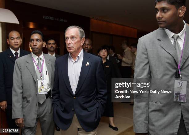 Mayor Michael Bloomberg is flanked by hotel staff as he walks through the lobby of the Swissotel the Stamford in Singapore on his way to attend a...