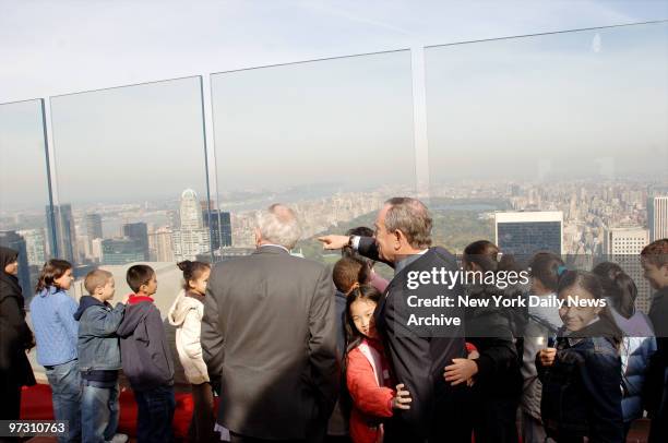 Mayor Michael Bloomberg is hugged by Min Ling Chan as he and David Rockefeller take in the view after a ceremony to re-open the "Top of the Rock,"...