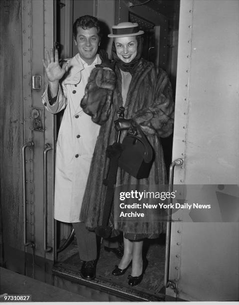 Tony Curtis and wife janet Leigh wave as tehy arrive in Grand Central. They are here for a week before traveling to Boston for the Premiere of his...