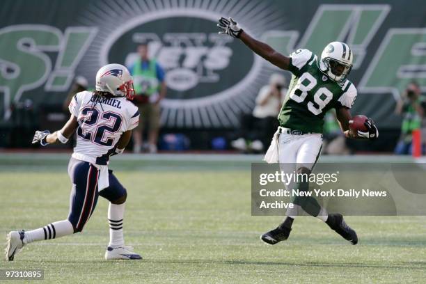 New York Jets' wide receiver Jerricho Cotchery catches a pass while defended by New England Patriots' Asante Samuel during a game at Giants Stadium....