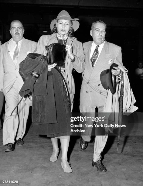 Greta Garbo arried on Ile de France. In the company of unidentified escort, she leaves pier.