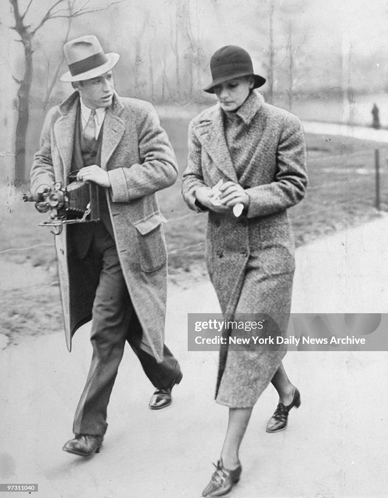 Greta Garbo being harried by a reporter as she wallks throug