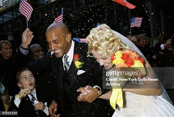 David Belafonte and his bride, Danish model Malene Mathiesen, walk hand-in-hand through a storm of confetti after their wedding at the Bryant Park...