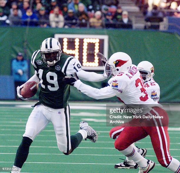 New York Jets' Keyshawn Johnson makes a run toward the end zone in the first half as Arizona Cardinals' Aeneas Williams chases him during game at...