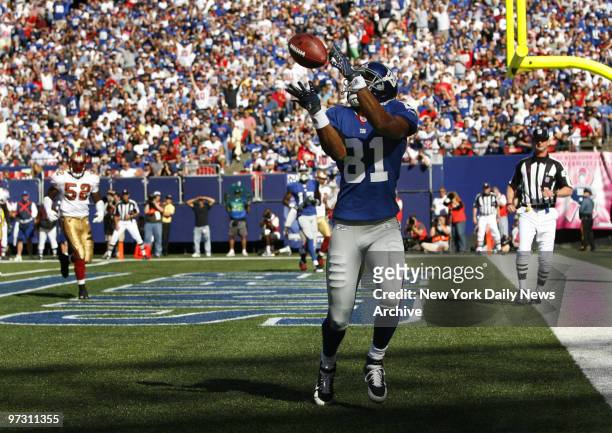 Giants Amani Toomer catches a touchdown pass in the first quarter during Sunday's game between the New York Giants and the San Francisco 49ers at...