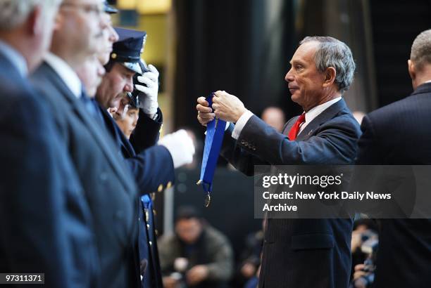 Mayor Michael Bloomberg presents medals to police officers during a ceremony at the Winter Garden in the World Financial Center. Two detectives and...