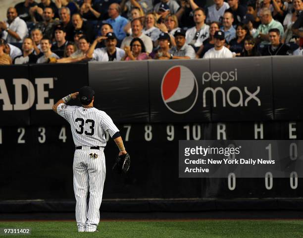 New York Yankees right fielder Nick Swisher salutes the fans in the bleachers at the beginning of the game when the New York Yankees played the...