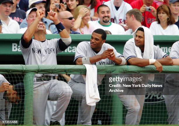 New York Yankees' Robinson Cano and Bobby Abreu look on in the dugout as Alex Rodriguez points to the sky during the eighth inning of a game against...