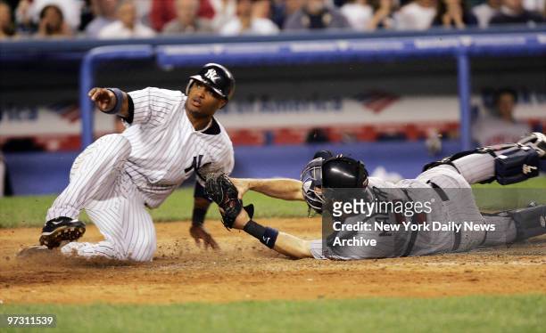 New York Yankees' Robinson Cano beats the tag of Minnesota Twins' catcher Joe Mauer to score on a single in the sixth inning of a game at Yankee...