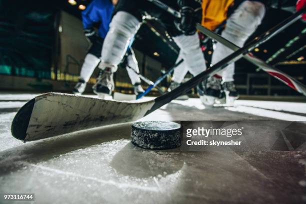 close up of ice hockey puck and stick during a match. - hockey player stock pictures, royalty-free photos & images