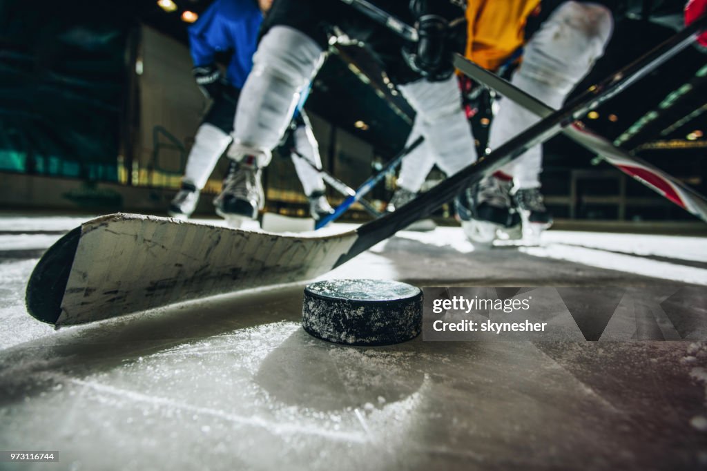 Close up of ice hockey puck and stick during a match.