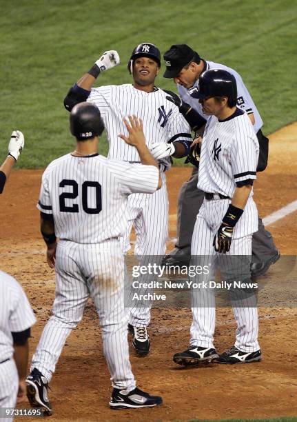 New York Yankees' Robinson Cano is congratulated after crossing the plate following his three-run homer in the third inning of a game against the...