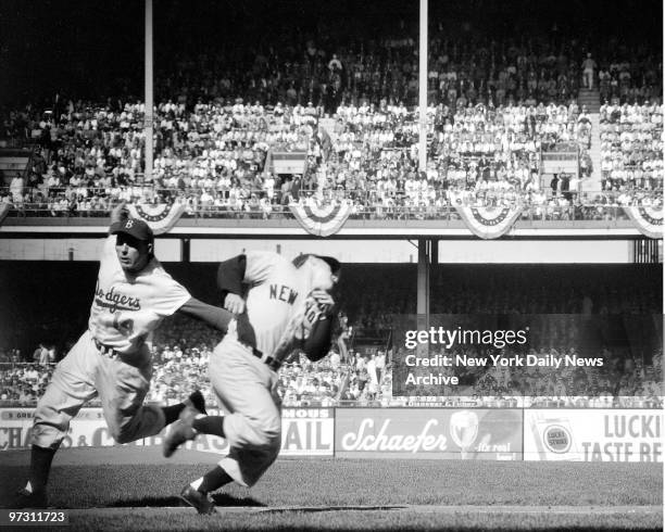 Gil Hodges lunges to tag Yogi Berra as the Yankee backstop tries to squirm out of the way of his first-inning roller. Yogi bashed a homer and single...