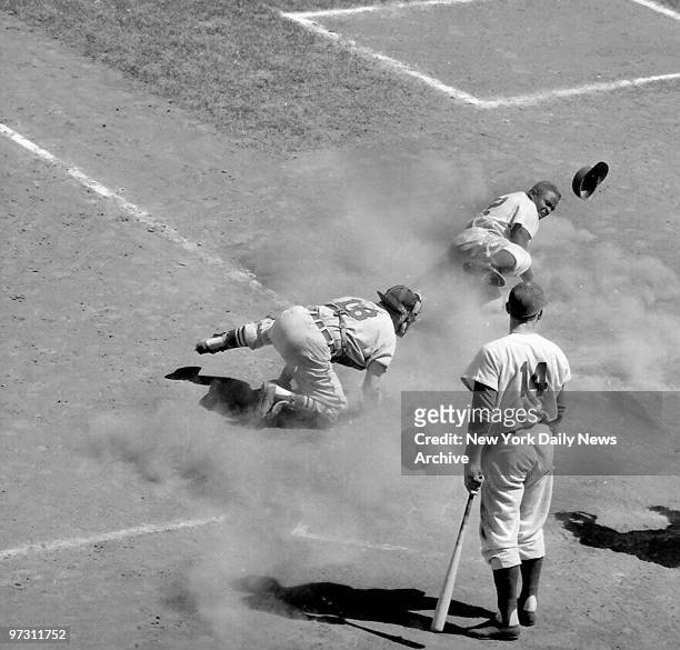 Gil Hodges stands aside watching the action as Burbink of the St. Louis Cardinals tags Jackie Robinson of the Brooklyn Dodgers to make the third out....