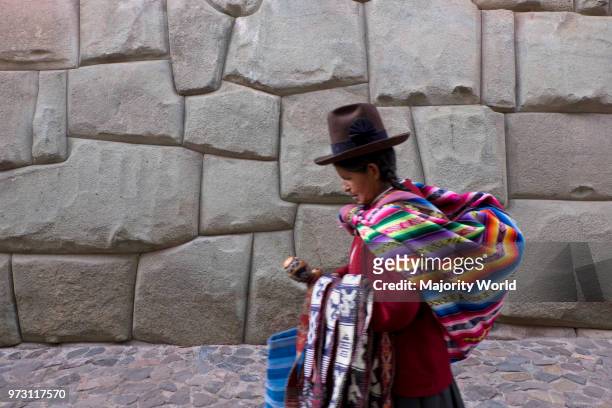 Native Quechua Traders By Old Inca Stone Walls In The Streets Of Cusco. Peru.