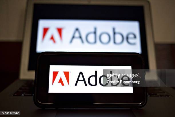 The Adobe Systems Inc. Logo is displayed on an Apple Inc. IPhone and laptop computer in an arranged photograph taken in Tiskilwa, Illinois, U.S., on...