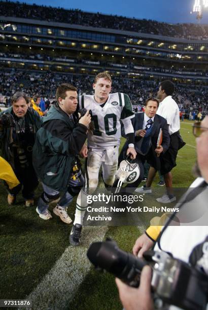 New York Jets' quarterback Chad Pennington walks off the field surrounded by media after losing to the Oakland Raiders, 30-10, in the AFC divisional...