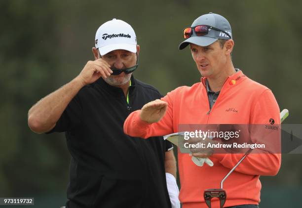 Justin Rose of England talks with caddie Mark Fulcher during a practice round prior to the 2018 U.S. Open at Shinnecock Hills Golf Club on June 13,...