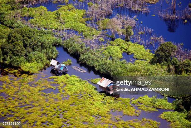Two huts, built on natural peat, are seen outside Pekanbaru, Riau, 02 November 2007. Annualy, Riau losses about 182.140 hectars of its peat,...