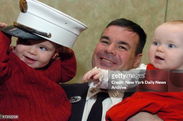 John Sullivan's 2-year-old son, John, tries on dad's new fire chief's hat while 8-month-old daughter Grace just seems to be enjoying the scene....