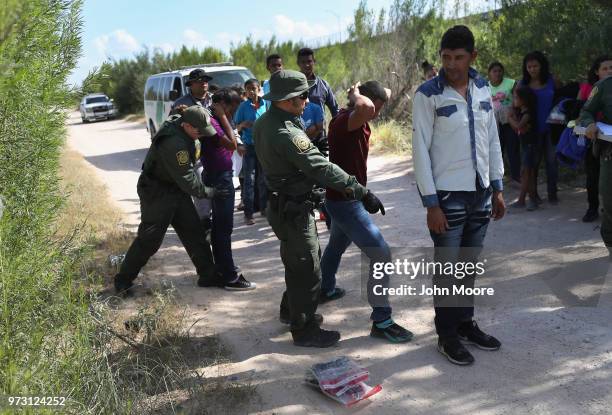 Border Patrol agents take a group of Central American asylum seekers into custody on June 12, 2018 near McAllen, Texas. The immigrant families were...