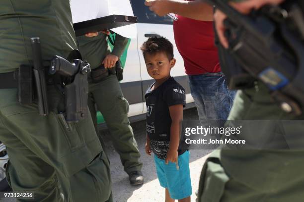 Border Patrol agents take into custody a father and son from Honduras near the U.S.-Mexico border on June 12, 2018 near Mission, Texas. The asylum...