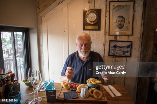 Sir Robin Knox-Johnston poses for a photograph as he is served a steak meal in the Chain Locker public house besides the harbour in Falmouth on June...