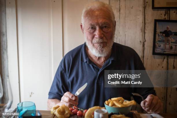 Sir Robin Knox-Johnston poses for a photograph as he is served a steak meal in the Chain Locker public house besides the harbour in Falmouth on June...