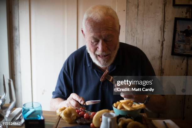 Sir Robin Knox-Johnston poses for a photograph as he is served a steak meal in the Chain Locker public house besides the harbour in Falmouth on June...