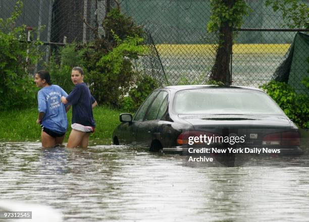 Girls decide to take a hike after leaving their car in high water at 23rd Ave. And Bell Blvd. Shopping center in Bayside, Queens, after area was...