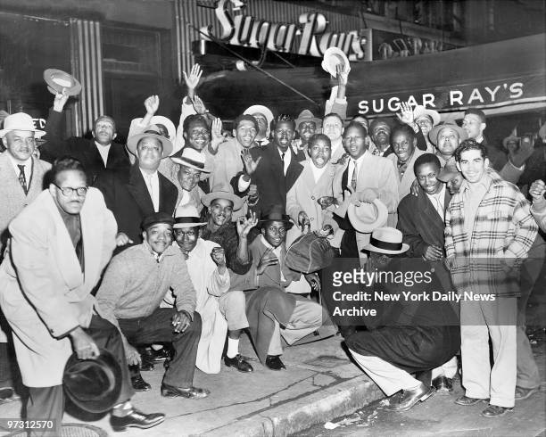Sugar Ray Robinson's rooters whoop it up outside his Harlem bar after Ray regained his middleweight title from Bobo Olson. Olson admitted that Ray's...
