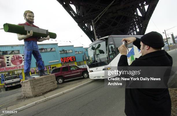 Tourist takes a picture of the "Muffler Man" under the Pulaski Skyway in Kearny, N.J., one of the stops on a tour of locations that appear in the...