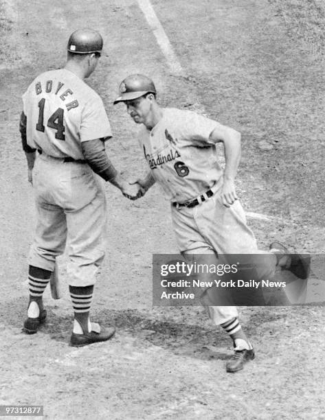 St. Louis Cardinals' slugger Stan Musial is congratulated by Boyer as he crosses the plate after hitting the first homer in game against the New York...