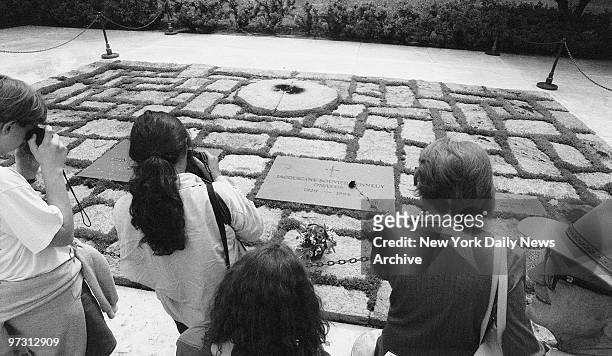 Tourists visit the graves of Jackie Onassis and President John F. Kennedy at the Arlington National Cemetary in Arlington, Va.