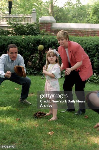 Mayor Rudolph Giuliani, the city's First Yankee Fan, and wife Donna Hanover give daughter Caroline a lesson in the fine art of making the bat meet...