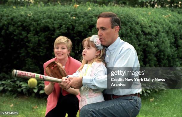 Mayor Rudolph Giuliani, the city's First Yankee Fan, and wife Donna Hanover give daughter Caroline a lesson in the fine art of making the bat meet...