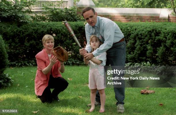 Mayor Rudolph Giuliani, the city's First Yankee Fan, and wife Donna Hanover give daughter Caroline a lesson in the fine art of making the bat meet...